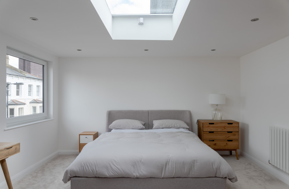 Design ideas for a large modern guest bedroom in London with white walls, carpet and grey floors.
