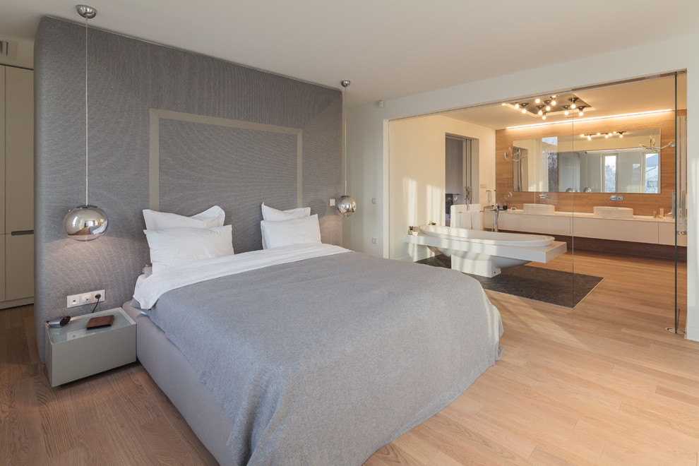 Modelo de dormitorio contemporáneo con suelo de madera clara