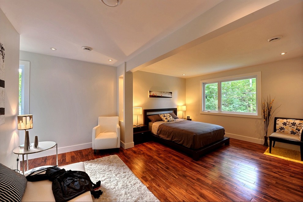 Imagen de dormitorio minimalista con paredes grises y suelo de madera oscura