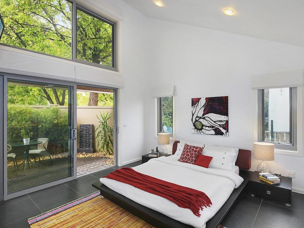 Пример оригинального дизайна: маленькая хозяйская спальня в современном стиле с белыми стенами, черным полом и полом из керамогранита без камина для на участке и в саду