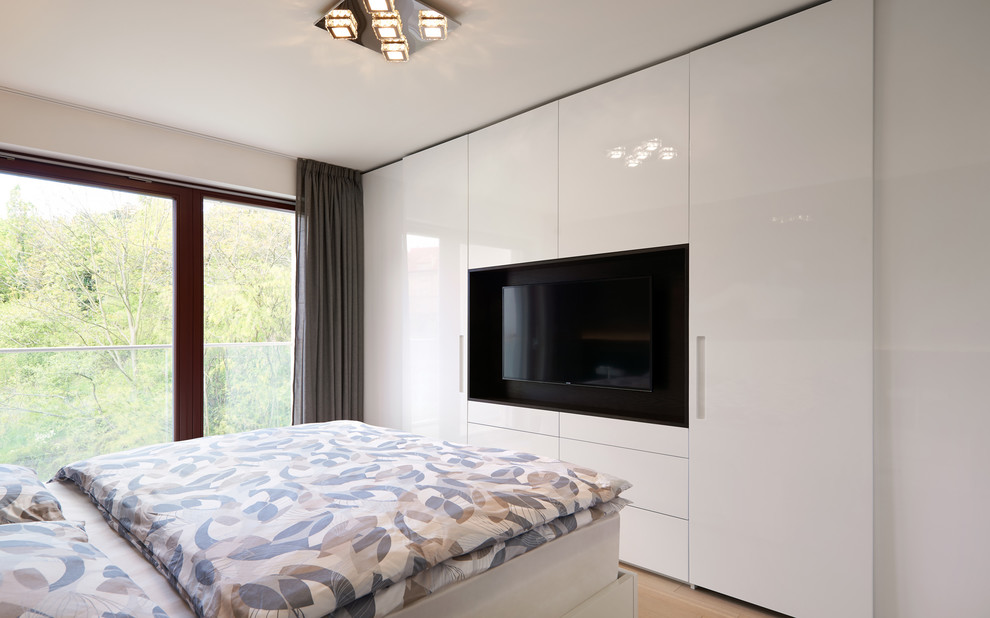 Cette image montre une chambre parentale minimaliste de taille moyenne avec un mur marron, parquet clair, aucune cheminée et un sol beige.