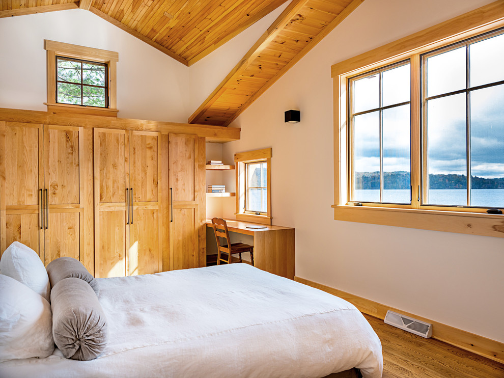 Esempio di una camera da letto stile rurale con pareti bianche, pavimento in legno massello medio e pavimento marrone