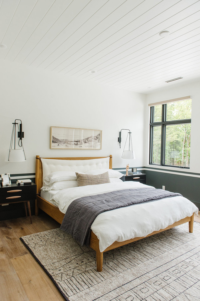 Ejemplo de habitación de invitados de estilo de casa de campo grande con paredes blancas y suelo de madera clara