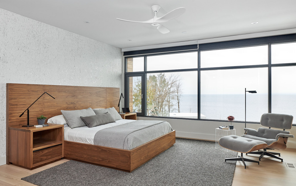 Mid-sized trendy master light wood floor and wallpaper bedroom photo in Toronto with white walls