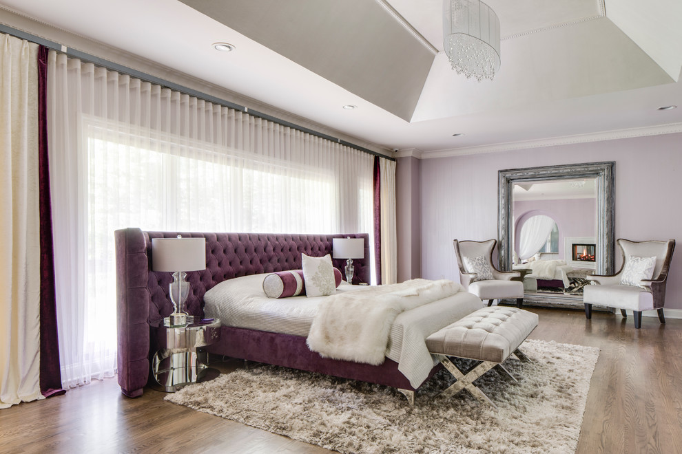 Inspiration pour une grande chambre parentale minimaliste avec un mur violet, un sol en bois brun, une cheminée double-face et un manteau de cheminée en carrelage.