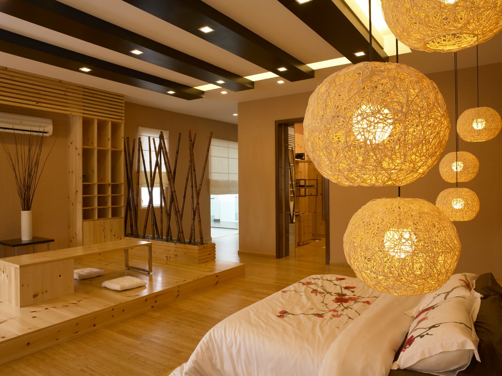 This is an example of a medium sized world-inspired guest bedroom in Other with brown walls, light hardwood flooring and brown floors.