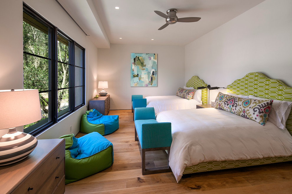 Imagen de habitación de invitados mediterránea de tamaño medio sin chimenea con paredes blancas y suelo de madera en tonos medios