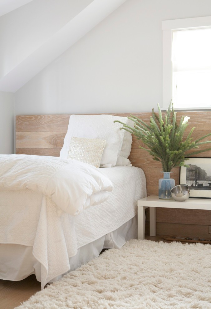 Immagine di una camera da letto tradizionale con pareti bianche e pavimento in legno massello medio
