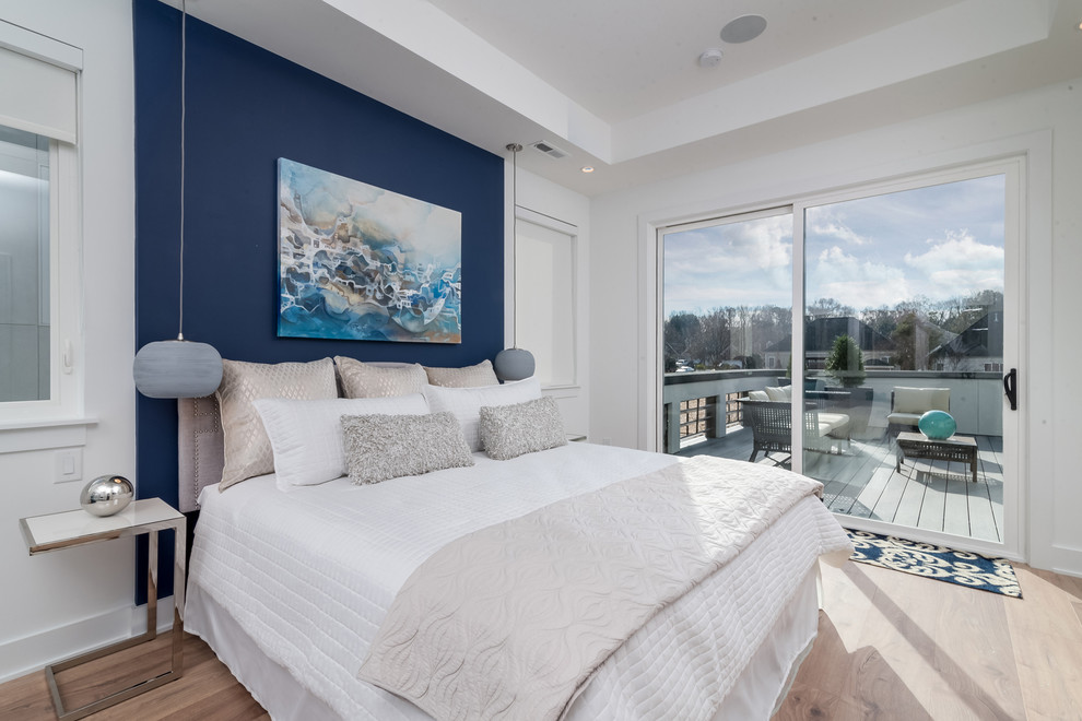 Imagen de dormitorio principal contemporáneo de tamaño medio con paredes azules, suelo laminado y suelo marrón