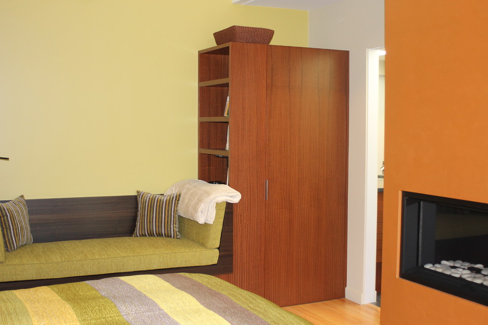 Modelo de dormitorio principal minimalista con chimenea lineal y marco de chimenea de yeso