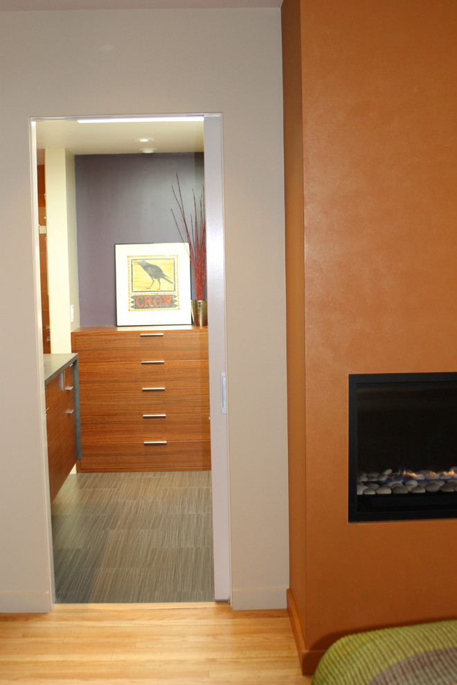 Imagen de dormitorio moderno con chimenea lineal y marco de chimenea de yeso