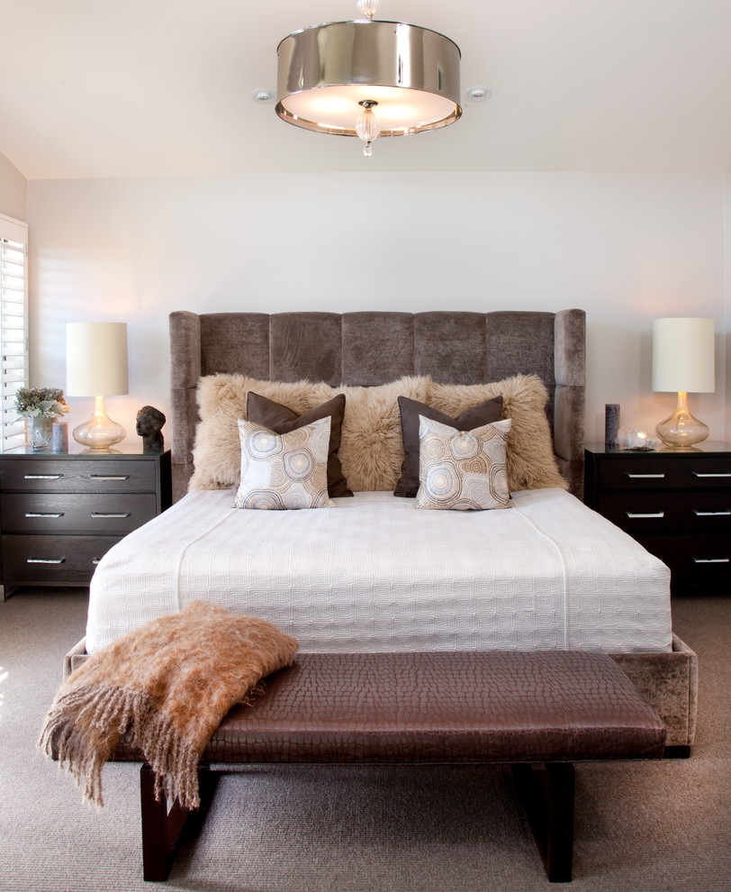 This is an example of a contemporary master bedroom in San Diego with white walls and carpet.