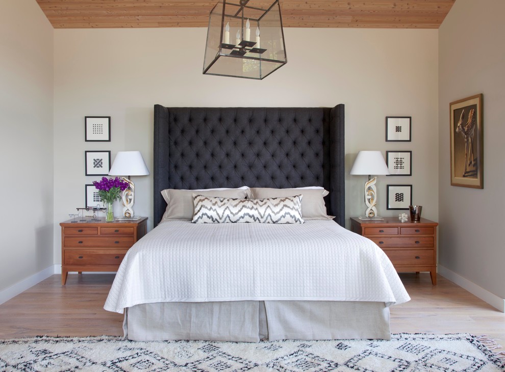 Imagen de dormitorio rural con paredes grises y suelo de madera clara