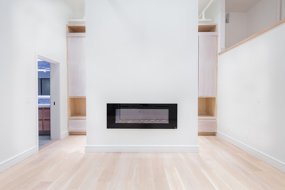 Großes Modernes Hauptschlafzimmer mit weißer Wandfarbe, hellem Holzboden, Gaskamin und Kaminumrandung aus Metall in New York