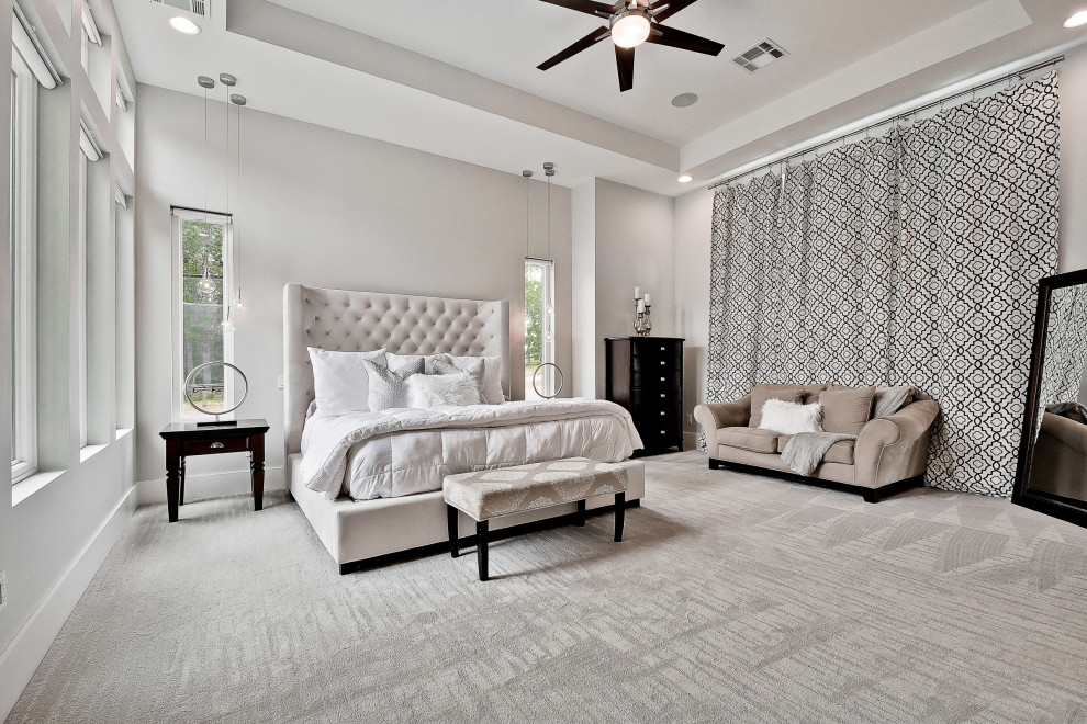 Modelo de dormitorio principal moderno grande con paredes grises, moqueta, suelo gris y bandeja