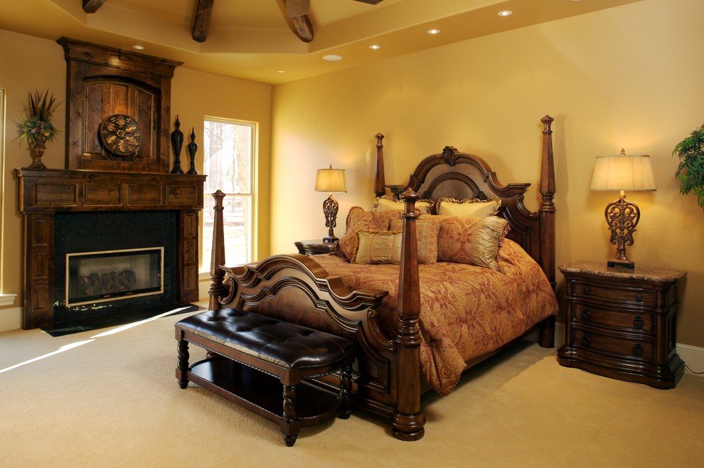 ダラスにある中くらいな地中海スタイルのおしゃれな主寝室 (ベージュの壁、カーペット敷き、標準型暖炉、木材の暖炉まわり) のインテリア