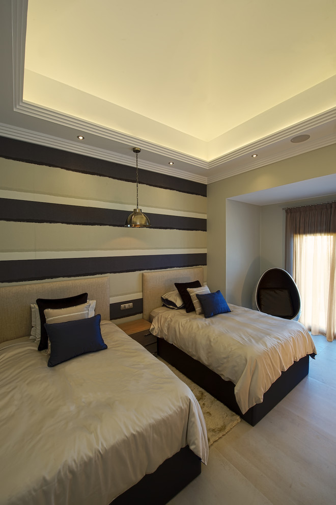 Modelo de habitación de invitados actual de tamaño medio sin chimenea con paredes multicolor y suelo de madera clara