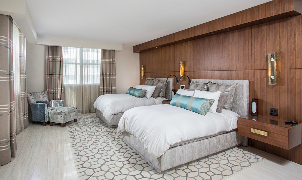 На фото: большая гостевая спальня (комната для гостей) в современном стиле с бежевыми стенами и полом из известняка без камина