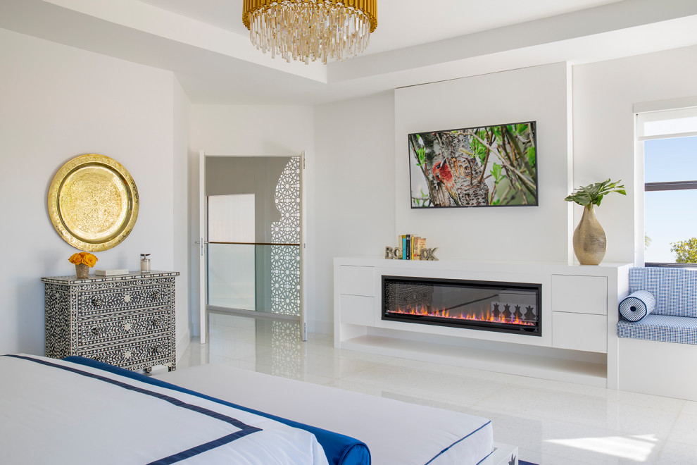 Großes Modernes Hauptschlafzimmer mit weißer Wandfarbe, Marmorboden, Hängekamin, Kaminumrandung aus Holz und weißem Boden in Miami