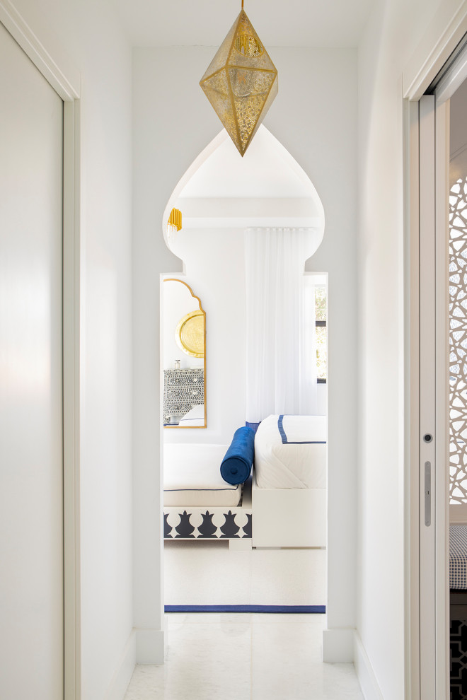 На фото: большая хозяйская спальня в стиле модернизм с белыми стенами, мраморным полом, подвесным камином, фасадом камина из дерева и белым полом
