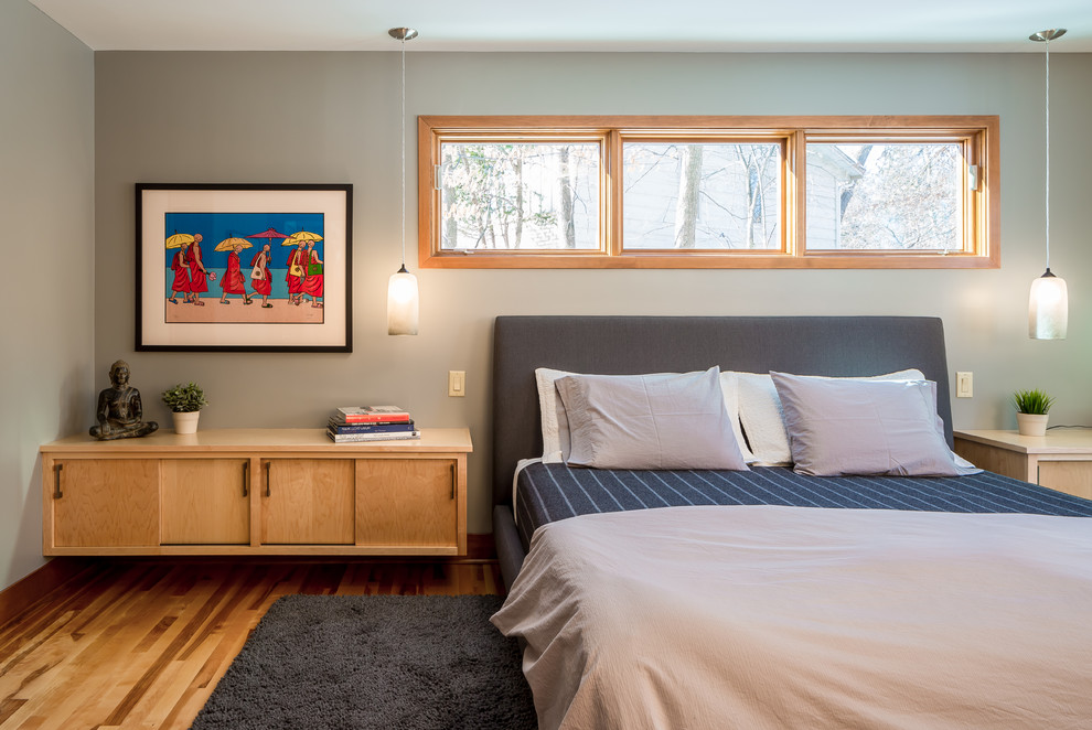 Diseño de dormitorio principal contemporáneo sin chimenea con paredes grises y suelo de madera en tonos medios