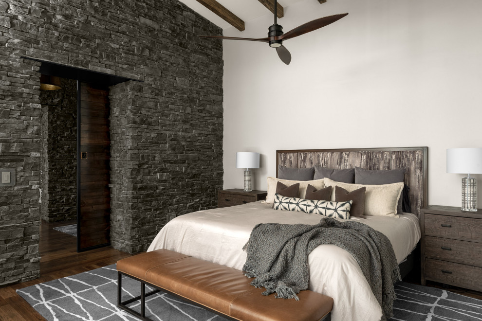 Diseño de dormitorio principal rústico de tamaño medio con paredes blancas, suelo de madera en tonos medios y suelo marrón