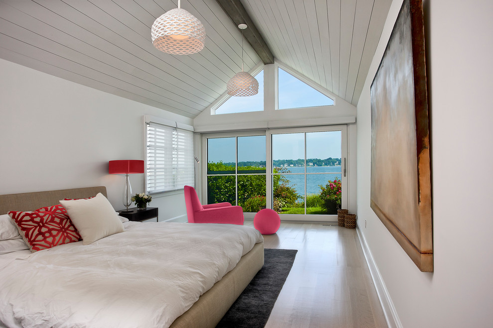 Photo of a medium sized coastal master and grey and pink bedroom in New York with white walls, light hardwood flooring, no fireplace and beige floors.