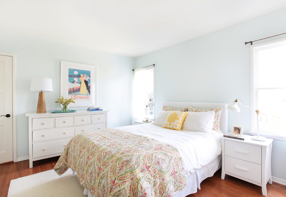 Réalisation d'une chambre parentale bohème de taille moyenne avec un mur bleu et parquet clair.
