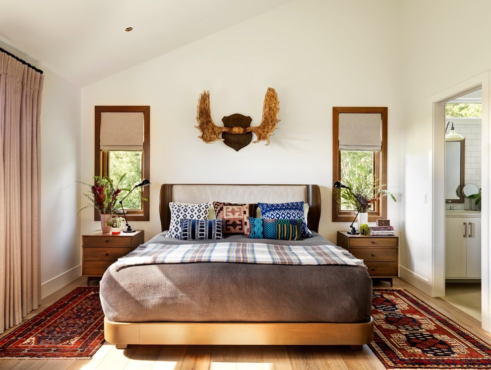 Modelo de dormitorio de estilo de casa de campo con paredes blancas y suelo de madera en tonos medios