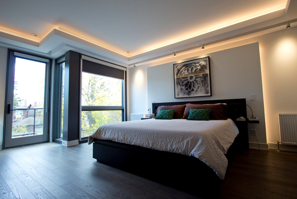 Großes Modernes Hauptschlafzimmer ohne Kamin mit weißer Wandfarbe und braunem Holzboden in Toronto