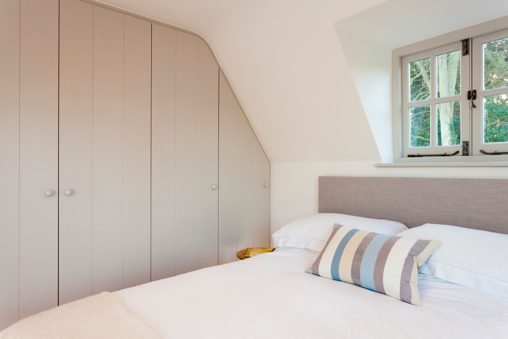 Diseño de dormitorio principal de estilo de casa de campo de tamaño medio con paredes blancas y suelo de madera en tonos medios