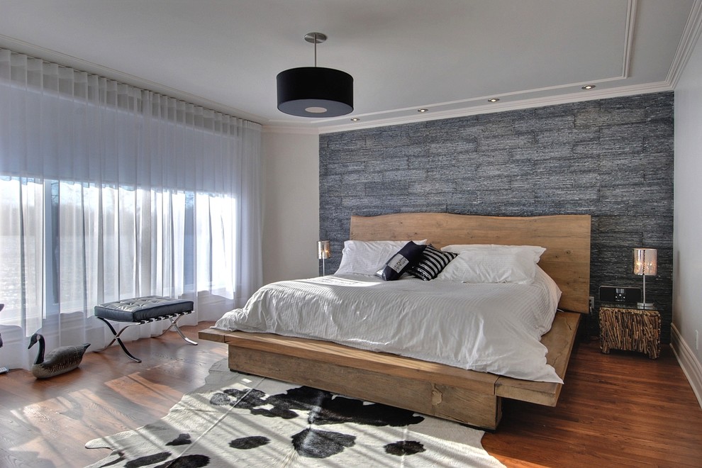 Inspiration pour une chambre parentale design avec un mur gris et un sol en bois brun.