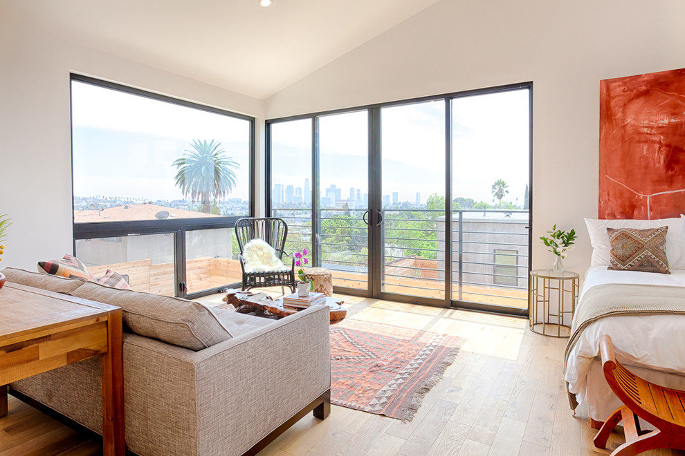 Inspiration for a contemporary guest light wood floor bedroom remodel in Other with white walls