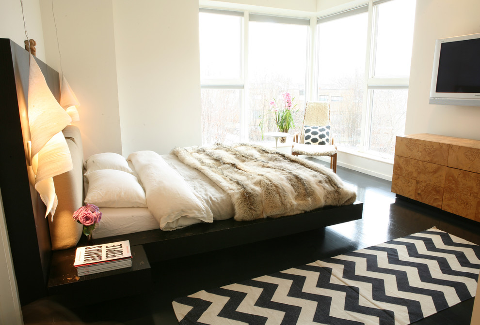 Стильный дизайн: спальня в современном стиле с бежевыми стенами, темным паркетным полом и черным полом - последний тренд
