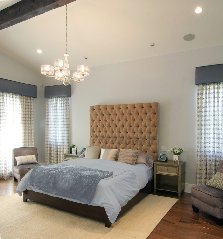 Imagen de dormitorio principal mediterráneo grande con paredes azules, suelo de madera en tonos medios, todas las chimeneas y marco de chimenea de piedra