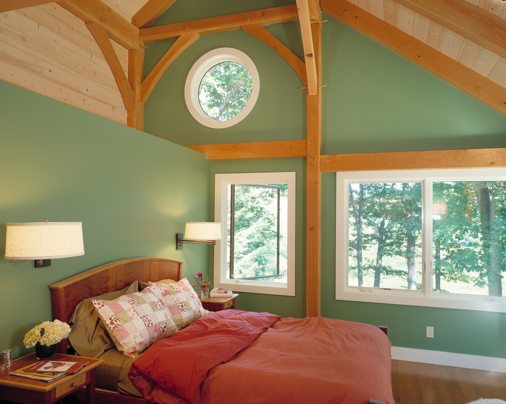 Uriges Hauptschlafzimmer mit grüner Wandfarbe und braunem Holzboden in Boston
