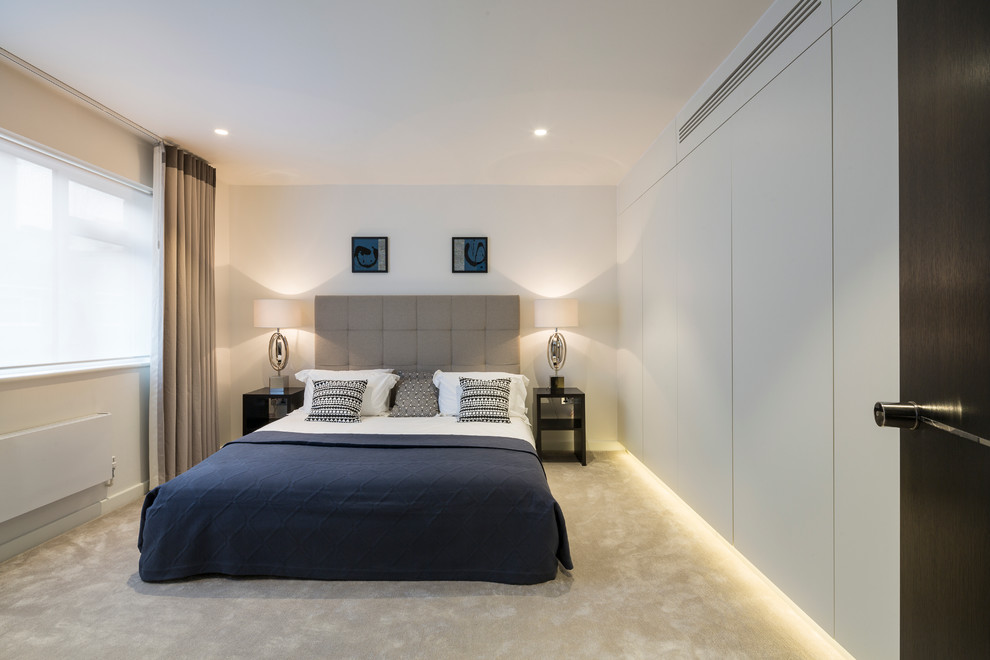 Photo of a medium sized contemporary guest bedroom in London with white walls and carpet.