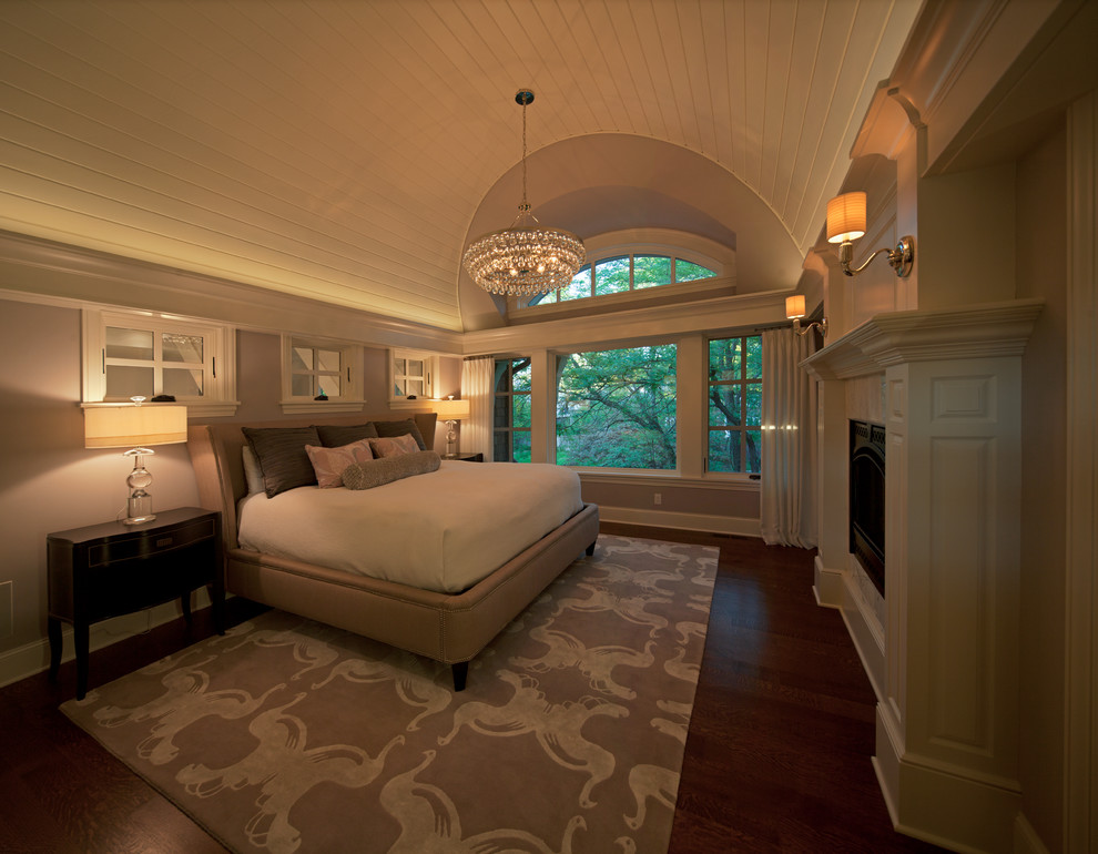 Modelo de dormitorio principal clásico renovado con paredes beige y suelo de madera oscura