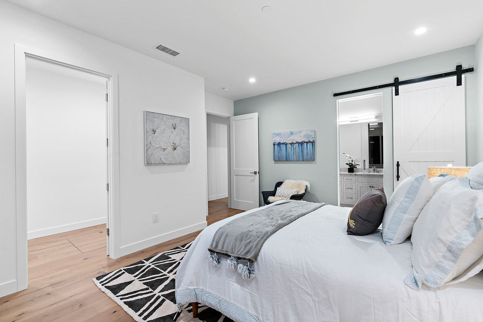 Exemple d'une grande chambre d'amis moderne avec un mur blanc, parquet clair, aucune cheminée et un sol multicolore.