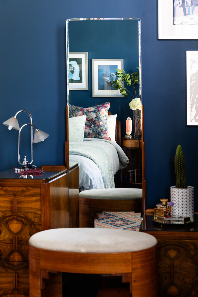 Imagen de habitación de invitados bohemia de tamaño medio con paredes azules y suelo de madera en tonos medios