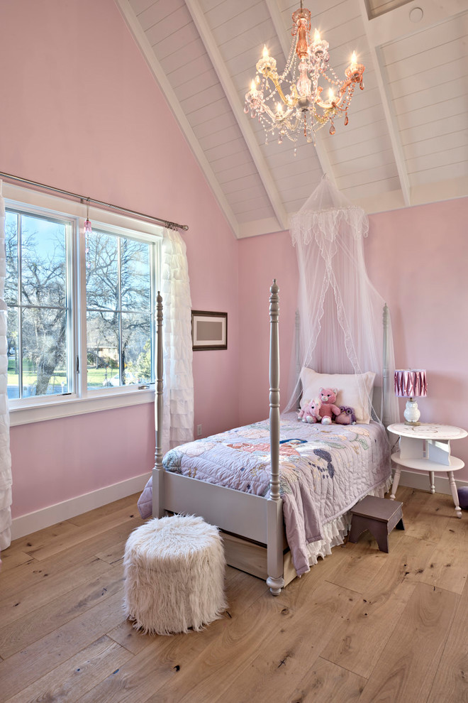 Foto på ett mellanstort lantligt sovrum, med rosa väggar och ljust trägolv
