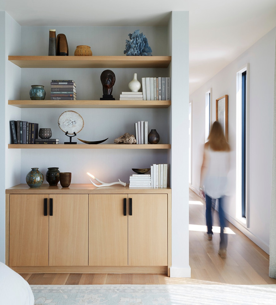 Modelo de dormitorio principal minimalista grande con paredes grises, suelo de madera clara y suelo marrón