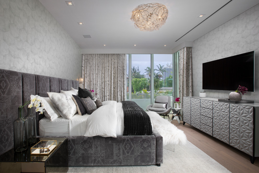 Eclectic master and grey and brown bedroom in Miami with grey walls, medium hardwood flooring and brown floors.