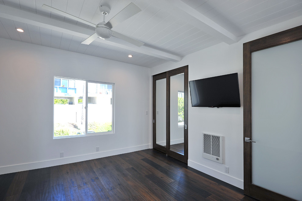 Modelo de habitación de invitados actual de tamaño medio con paredes blancas y suelo de madera en tonos medios