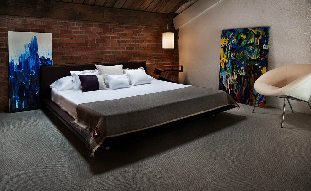 Immagine di una camera da letto industriale con pareti bianche, moquette e nessun camino