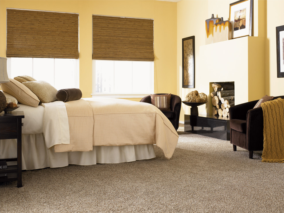 На фото: хозяйская спальня среднего размера в классическом стиле с желтыми стенами, ковровым покрытием, стандартным камином и фасадом камина из штукатурки с