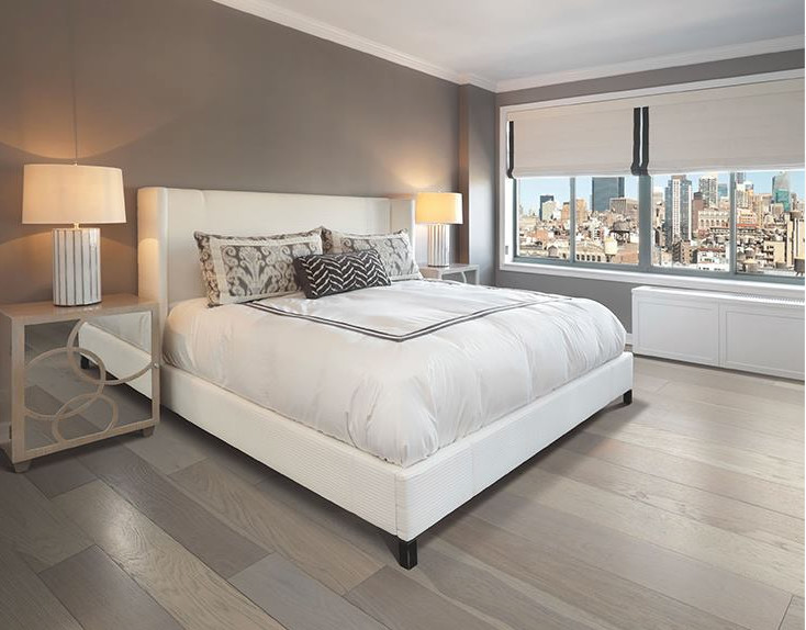 Modelo de dormitorio principal actual grande con paredes grises y suelo de madera en tonos medios