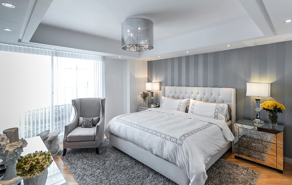 Imagen de dormitorio principal contemporáneo de tamaño medio con paredes grises y suelo de madera clara