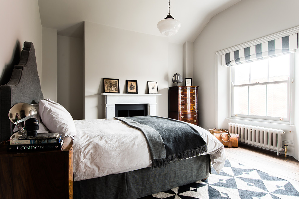 Ispirazione per una camera da letto design di medie dimensioni con pareti bianche e camino classico