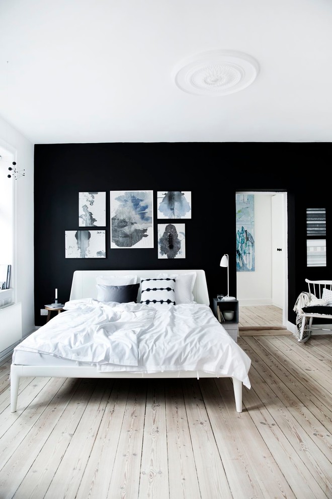 Réalisation d'une chambre parentale nordique de taille moyenne avec un mur noir et parquet clair.
